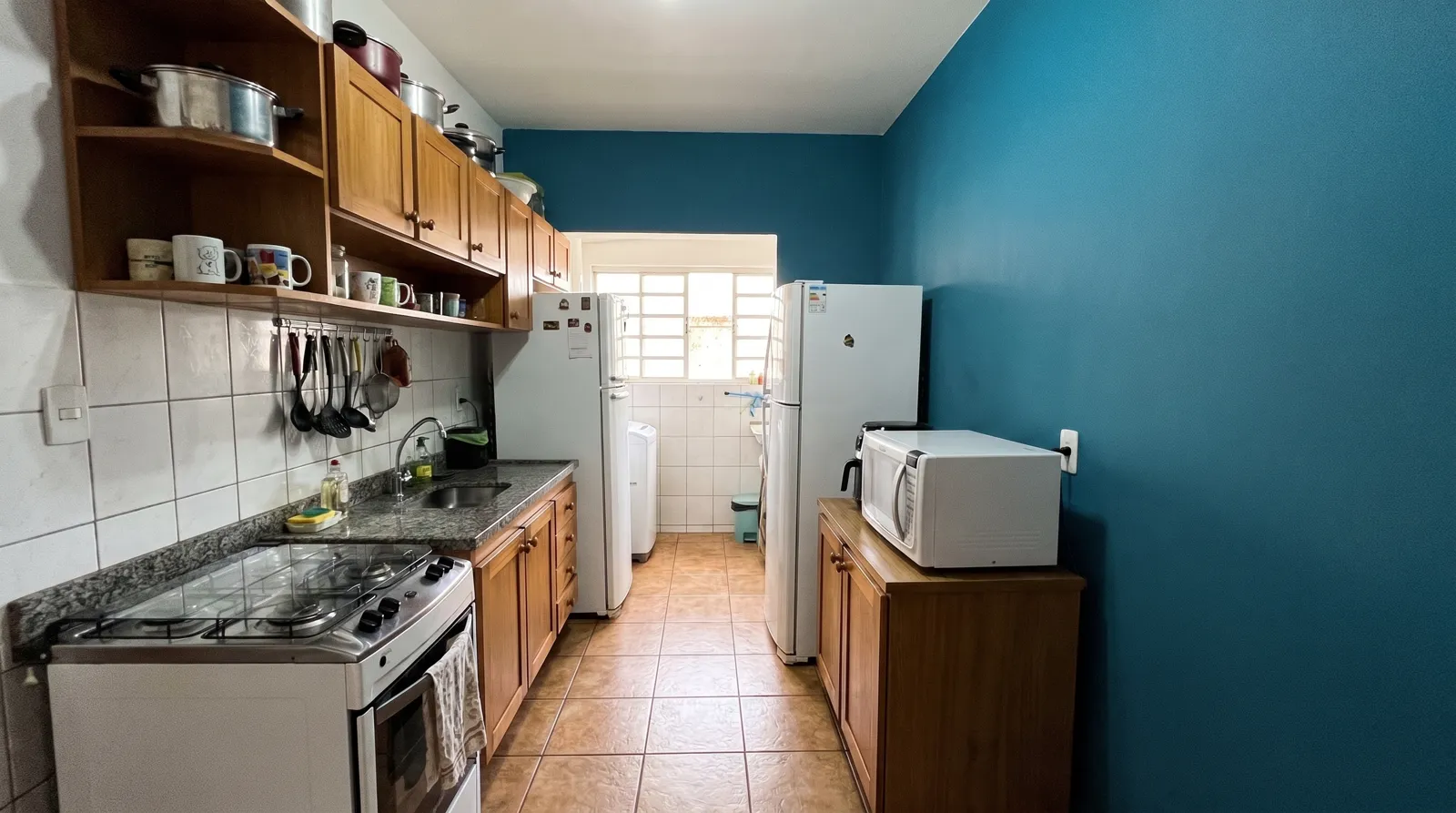 Cozinha com parede de destaque azul petróleo